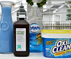 various cleaning products are sitting on a table next to each other, including detergent and deodorant