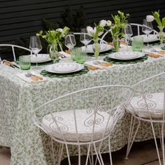 the table is set with white chairs and green tablecloths, which have flowers on them