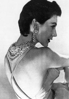 an old black and white photo of a woman with her back turned to the camera