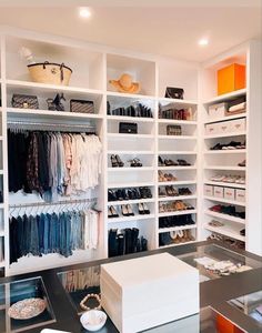 an organized closet with white shelving and drawers