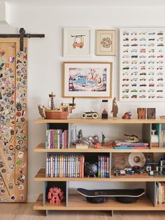 a skateboard is sitting on top of a book shelf in front of pictures and posters