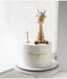 a white cake with a giraffe on top and the number one on it