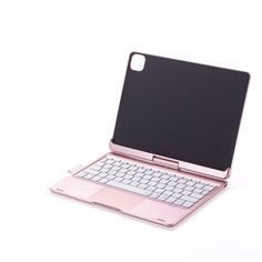 an open pink laptop computer sitting on top of a white table next to a keyboard