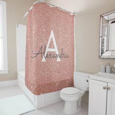 a bathroom with a shower curtain that has the letter a on it and is decorated in glitter