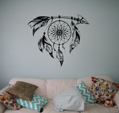 a living room with a white couch and wall decal that has a dream catcher on it