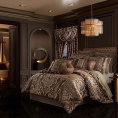 a bedroom with a large bed covered in brown and gold comforter set next to a chandelier