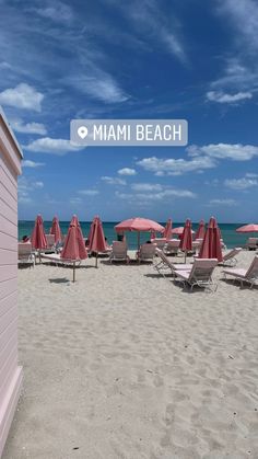 beach chairs and umbrellas are lined up on the sand