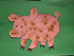 a paper cut out of a pig on a green background