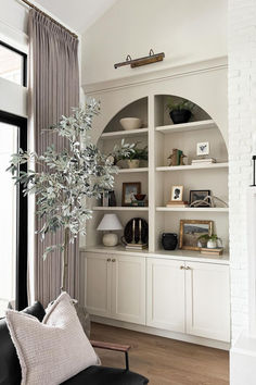 a living room filled with lots of furniture and bookshelves next to a window