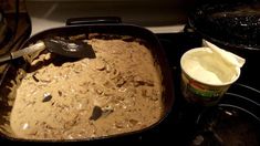 a pan filled with food sitting on top of a stove next to an ice cream container