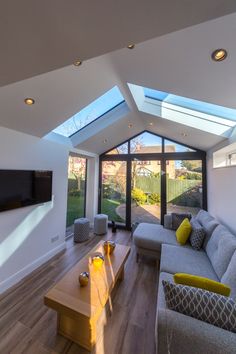 a living room filled with furniture and a flat screen tv mounted to the side of a wall