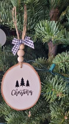 a christmas ornament hanging from a tree with the word christmas written on it