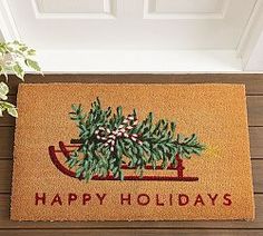 a happy holidays door mat with a christmas tree on it