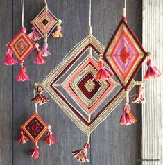 some tassels hanging from a wooden wall with red and pink decorations on it