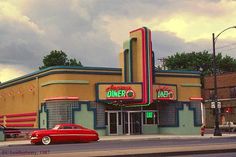 a red car parked in front of a theater