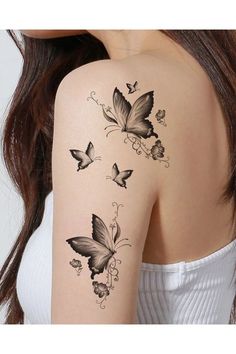 the back of a woman's shoulder with butterflies on it