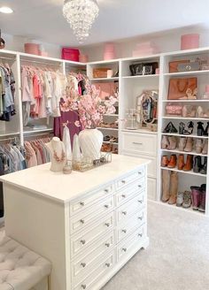 an organized closet with white drawers and lots of shoes on the shelves, chandelier hanging from the ceiling