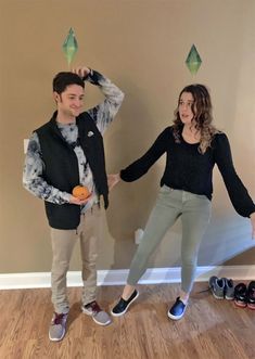 a man and woman standing next to each other in front of a wall with shoes on it