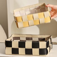 a person is holding an empty box in one hand and the other has a checkered pattern on it