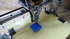 a machine that is making something blue in the middle of it's workbench