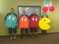 four people dressed up as pac - man and other characters standing in front of a door