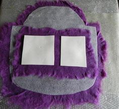 two pieces of paper are placed on top of a purple and gray surface with fuzzy edges