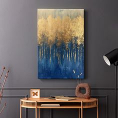 an abstract painting hangs on the wall above a console table with a lamp and vase