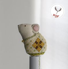 a small stuffed animal on top of a white pole in front of a white wall