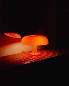 an orange lamp sitting on top of a tiled counter