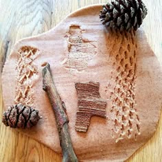 a wooden table topped with sand and pine cones