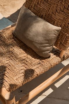 a brown pillow sitting on top of a wicker chair next to a wooden frame