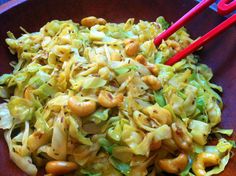 a bowl filled with noodles and vegetables next to chopsticks