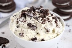 a white bowl filled with ice cream and oreo cookies next to some chocolate chips