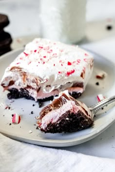 a piece of cake sitting on top of a white plate next to a glass of milk