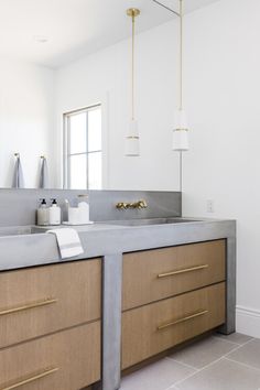 a bathroom with two sinks and gold handles