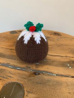 a knitted christmas pudding sitting on top of a wooden table