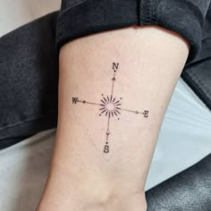 a woman's foot with a compass tattoo on the left side of her leg