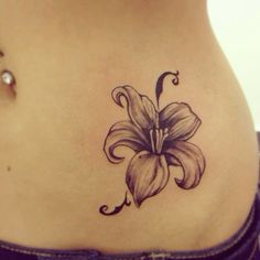 a woman's stomach with a flower tattoo on it