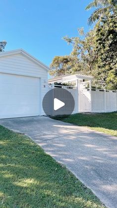 a white house with a driveway in front of it and a garage on the other side