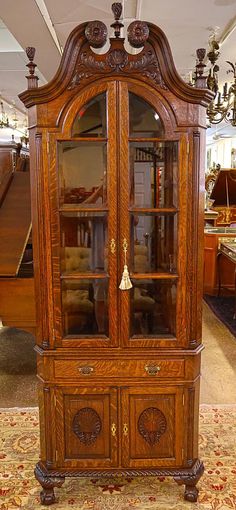 an old wooden china cabinet with glass doors