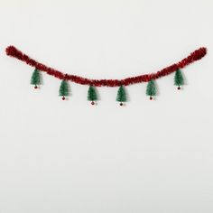 a red string with green christmas trees hanging from it