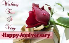 a red rose sitting on top of a box with the words wishing you a very happy anniversary