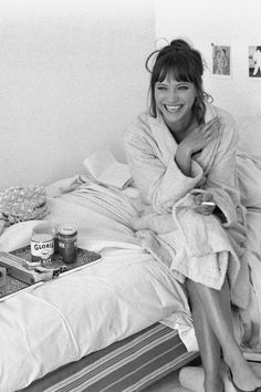 black and white photograph of a woman sitting on a bed