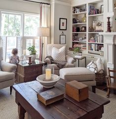 a living room filled with furniture and a fire place in front of a large window