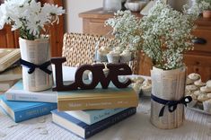 some books are stacked on top of each other and decorated with flowers in vases