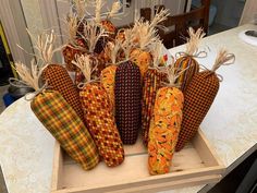 several decorative items are sitting on a table in the shape of pumpkins and corn stalks