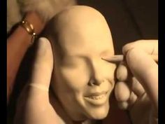 a close up of a mannequin's head with hands on the forehead