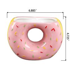 a pink doughnut shaped vase with sprinkles on it's sides