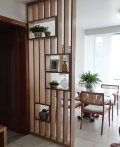 a living room filled with furniture next to a dining room table and two planters