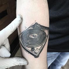 a person with a tattoo on their arm has a record player tattooed on his arm